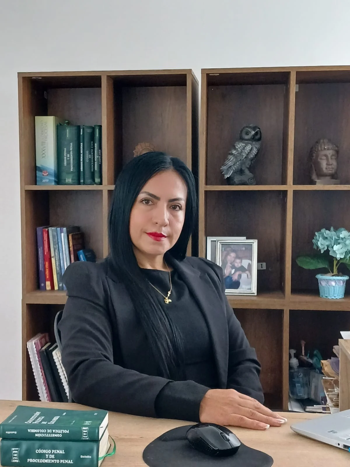 Dra. Nancy Aseneth Melo Canamejoy en su despacho jurídico con libros de derecho penal y constitución